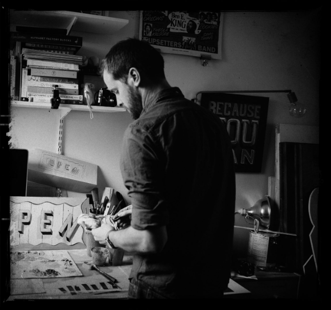 A man standing in front of a desk.