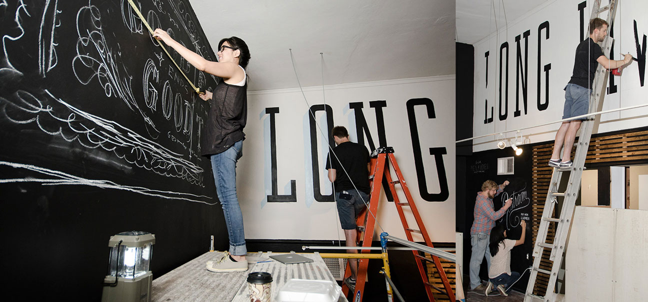 A woman is hanging on the wall while another person stands next to her.