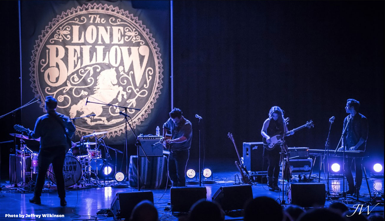 A band is playing on stage with the logo of one willow.